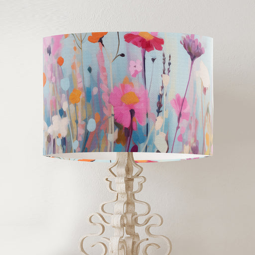 Delicate colourful wildflower design against a serene pale blue backdrop on a classic sized 30x21cm handcrafted fabric lampshade by artist Kelly Stevens-McLaughlan