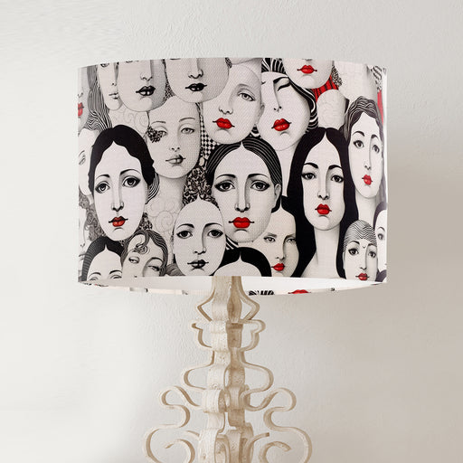 Monochrome womens faces with red lipstick cover this design on a classic sized 30x21cm handcrafted fabric lampshade by artist Kelly Stevens-McLaughlan
