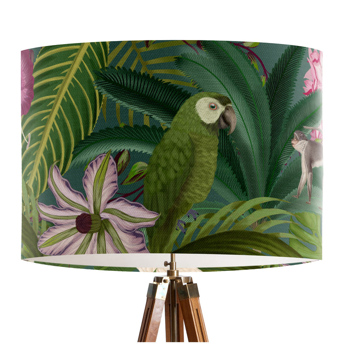 Parrots in white, green & blue along with monkeys sit amoungst green tropical leaves and pink flowers on a small sized 20x18cm handcrafted fabric lampshade by artist Kelly Stevens-McLaughlan