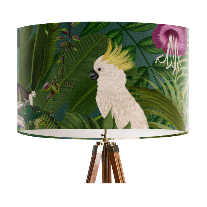 Parrots in white, green & blue along with monkeys sit amoungst green tropical leaves and pink flowers on a large sized 40x25cm handcrafted fabric lampshade by artist Kelly Stevens-McLaughlan